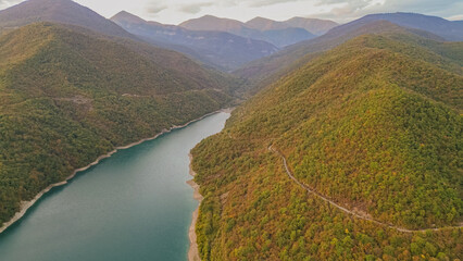 Obraz premium Aerial view of turquoise Zhinvali reservoir surrounded by green forested Caucasus mountains along Georgian Military Highway near Ananuri in Georgia country