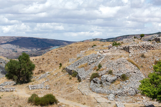 Stone ruins and ancient stairways at Hattusa archaeological site in Bogazkale, Turkey with scenic hilly landscape