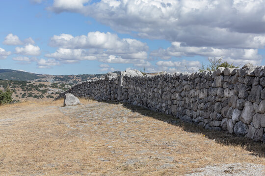 Ancient Upper City stone wall of Hattusa in Bogazkale, Turkey with mountainous background