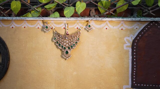 Indian bride wearing intricate silver bridal choker necklace with traditional floral garland backdrop