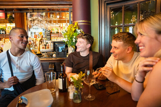 Friends laughing together in a traditional pub in London