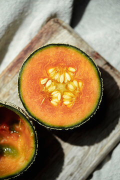 Fresh Melon Cut in Half on a Wooden Board With Natural Light