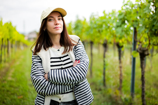 Young woman standing in a vineyard, illustrating the authentic Austrian countryside during the grape ripening season.