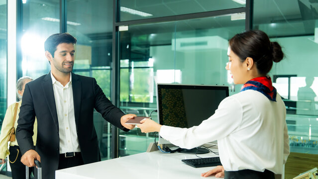 Airport staff greets a traveler at the service counter while assisting with travel preparation and creating a welcoming passenger experience.