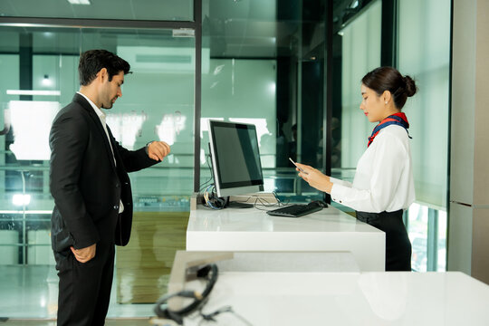 Business traveler receives personalized assistance from airport staff at a modern check-in counter representing professional service and seamless passenger support.

