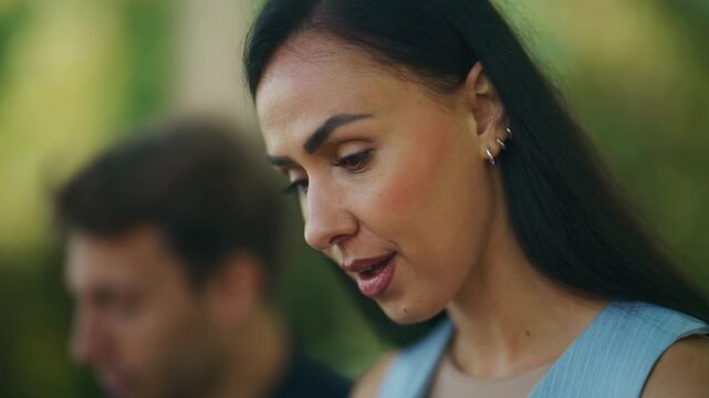 A happy businesswoman claps and smiles during an outdoor business meeting. She demonstrates engagement and positive emotion in this professional interaction.