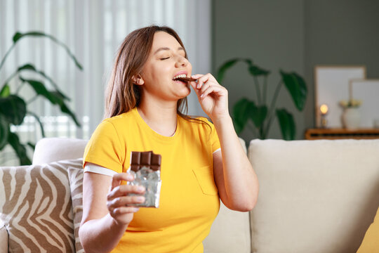 Woman biting a chocolate bar