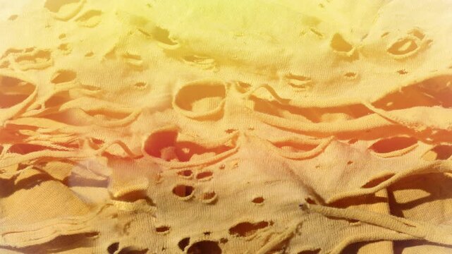 Seamless 4K looping vertical movement across layered sandstone yellow rag with holes.