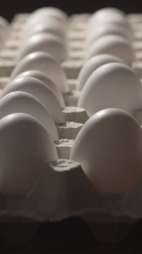 man's hands taking fresh white chicken eggs out of cardboard box