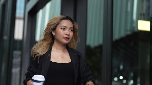 Businesswoman standing in a modern urban setting, holding her bag with a confident expression, representing professionalism, elegance, and readiness in a sleek and dynamic environment.