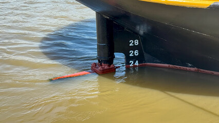 Close up of ship hull with draft marks and rudder in muddy harbor water in Antwerpen, België © Bjorn B