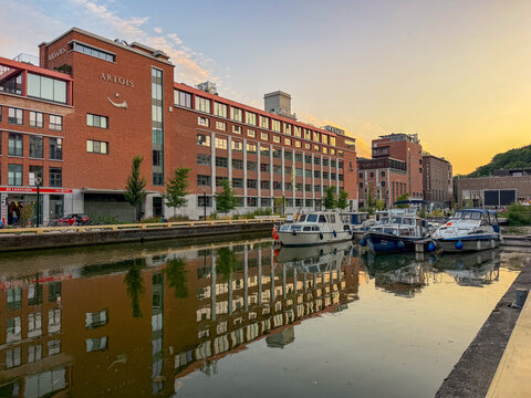Leuven, Belgium, July 16, 2026 - Stella Artois brewery building reflected in canal at sunset with moored boats at Jachthaven marina in Leuven, Belgi&euml;