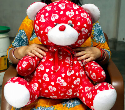 Woman Holding Red Teddy Bear with Heart Pattern Symbolizing Love