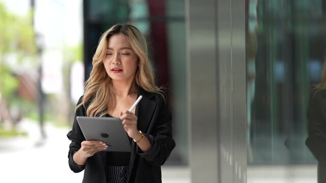 Confident businesswoman holding a tablet and stylus, emphasizing precision and adaptability in a contemporary workspace, blending style and functionality.