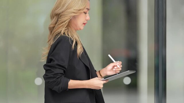 Confident businesswoman holding a tablet and stylus, emphasizing precision and adaptability in a contemporary workspace, blending style and functionality.