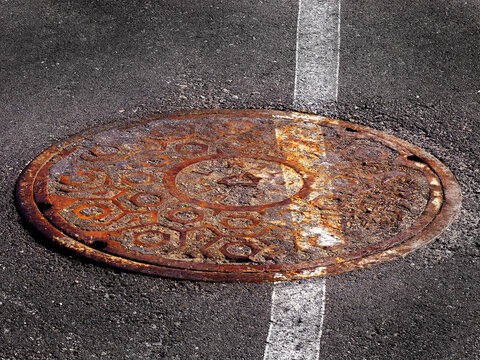 Manhole Cover Man Hole Iron Round Cover Worn and Rusty with White Painted Line Slanted and Off Kilter