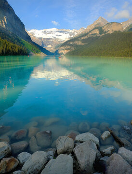 Several Groups of People in Red Canoes Floating on Brilliant Blue Lake Louise in the Wilderness Mountains Enjoying Nature Outdoors