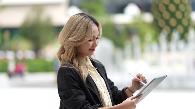 Confident businesswoman holding a tablet and stylus, emphasizing precision and adaptability in a contemporary workspace, blending style and functionality.
