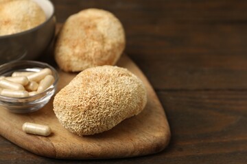 Functional mushrooms and pills on wooden table, closeup. Space for text © New Africa