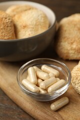 Functional mushrooms and pills on wooden table, closeup © New Africa