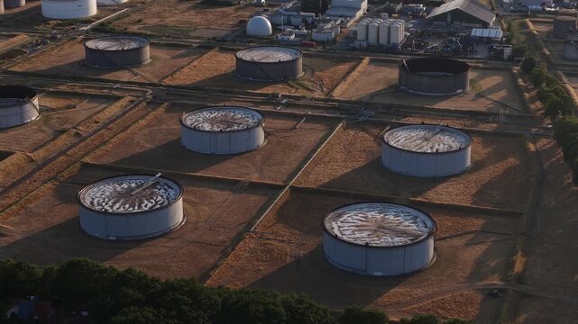Aerial view flying over an oil refinery storage tank farm