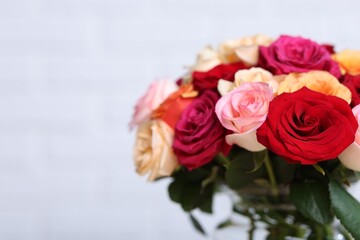 Fototapeta premium Beautiful bouquet of colorful roses in vase on white background, closeup. Space for text