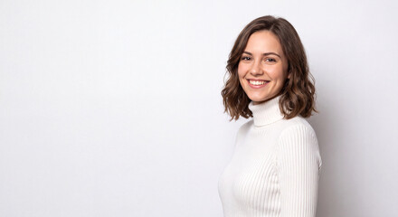 Fototapeta premium Portrait of a smiling young woman wearing a white turtleneck isolated on white background