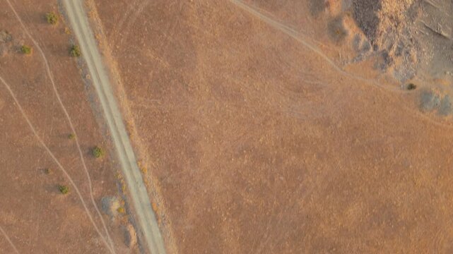 Drone flying over a barren dehesa landscape in Salamanca, Spain, showcasing the severe effects of water scarcity, desertification, drought, and summer heatwaves on nature
