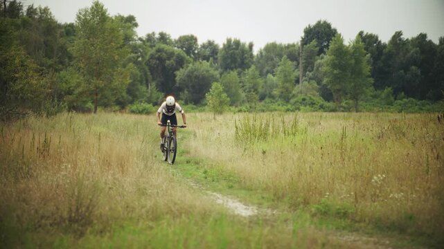 Cyclist Riding Mountain Bike On Field Trail. Athlete Outdoor Workout