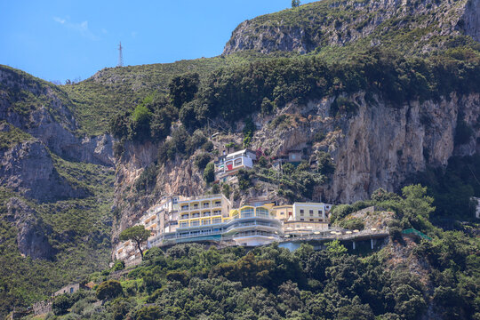 SALERNO, ITALY on March 25, 2024. The terraced architecture of the Grand Hotel Excelsior and surrounding buildings built into a steep rocky cliffside on the Amalfi Coast.