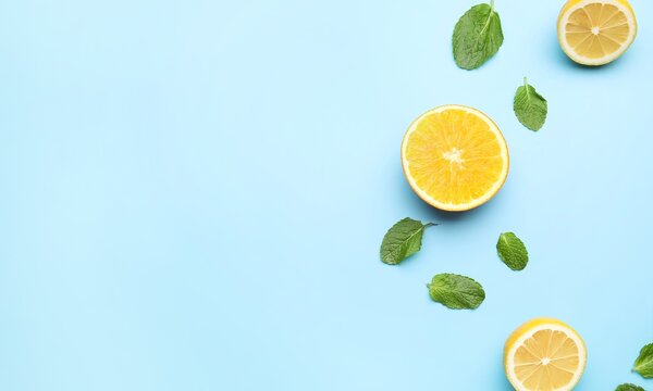 Fresh orange slices and mint leaves on bright blue background with flat lay background refreshing