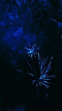 Blue festive fireworks exploding in night sky