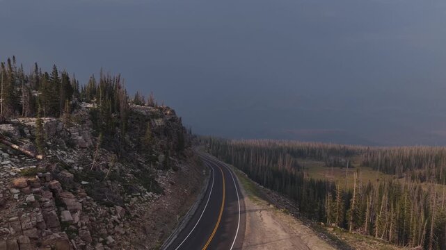 Aerial of winding highway 150 through Uinta Wasatch Cache National Forest Utah traversing a steep mountain slope with overcast skies