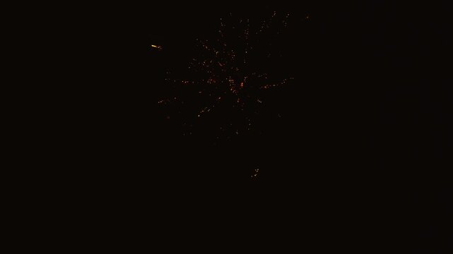 Spectacular red and gold fireworks exploding in night sky