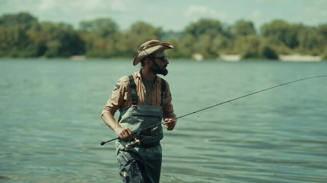 Fisherman Holding Spinning Rod Walking In River. Water Angling. Outdoor Activity Hobby
