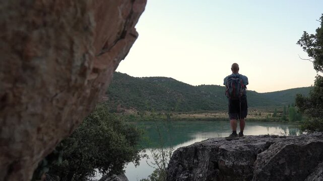 Hiker recording a video with the phone on the rock.