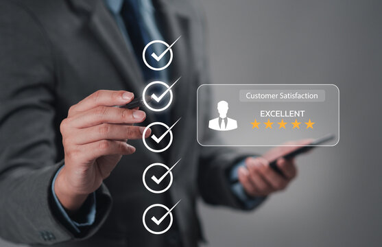 The hand is giving a five-star rating. The business person selects the smiley face icon on the virtual screen to express their satisfaction with the service. The rating received is very impressive.