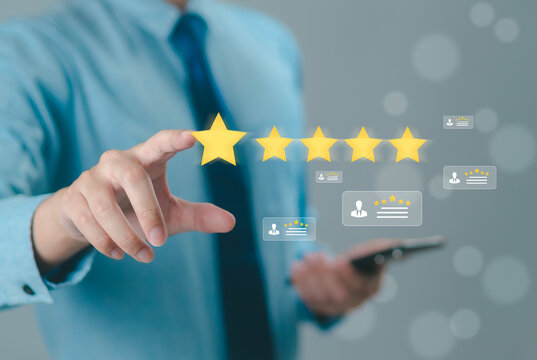 The hand is giving a five-star rating. The business person selects the smiley face icon on the virtual screen to express their satisfaction with the service. The rating received is very impressive.