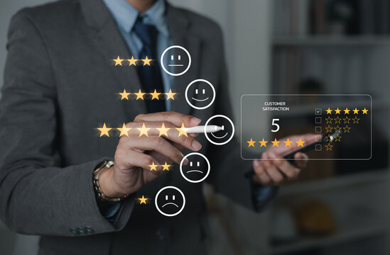 The hand is giving a five-star rating. The business person selects the smiley face icon on the virtual screen to express their satisfaction with the service. The rating received is very impressive.