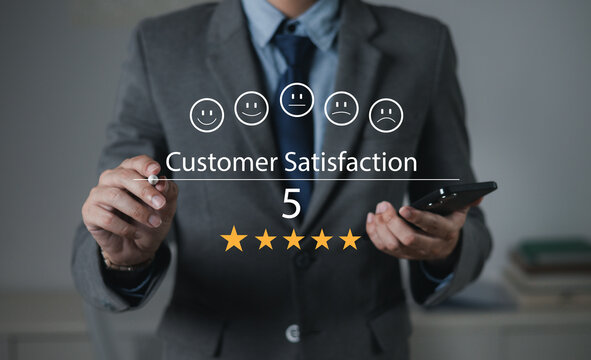 The hand is giving a five-star rating. The business person selects the smiley face icon on the virtual screen to express their satisfaction with the service. The rating received is very impressive.