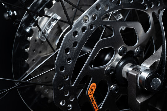Macro of the stainless steel gears and spokes on a mountain bike with a dark background
