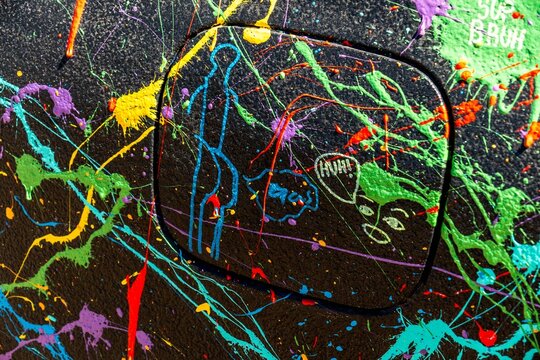 vandalized paint-splattered car in outdoor setting during daytime period close-up side view of cara.