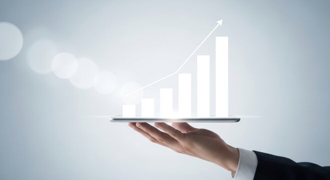 Hand holding a tablet displaying a growing bar chart with an upward trending arrow