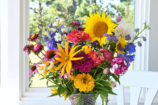 Bouquet of mixed flowers in a vase by a window, wildflowers 