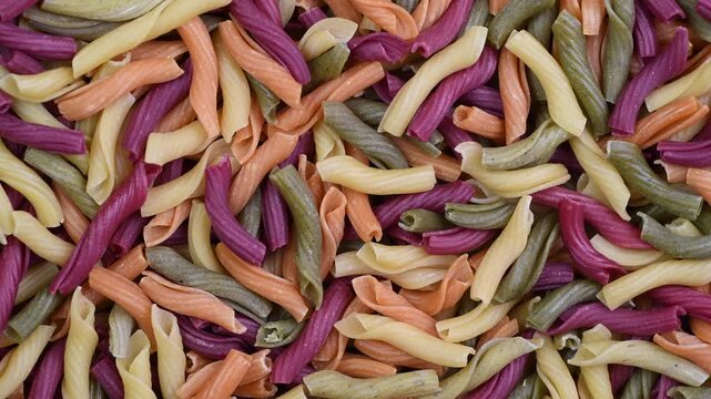 Raw pasta torchietti tricolor close-up, top view