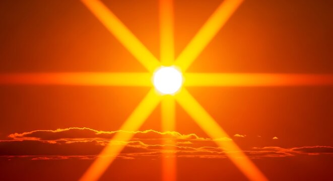 Bright sun with light rays shining through clouds at sunset