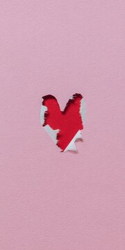 Pink paper torn showing red heart shape