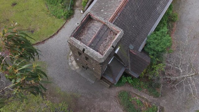 Aerial view of a medieval stone tower and building in the rain