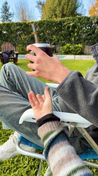 Close up of two hands sharing traditional yerba mate, Argentine drink in the garden a spring day. Latin Heritage, Uruguay Paraguay and Brazil typical social beverage