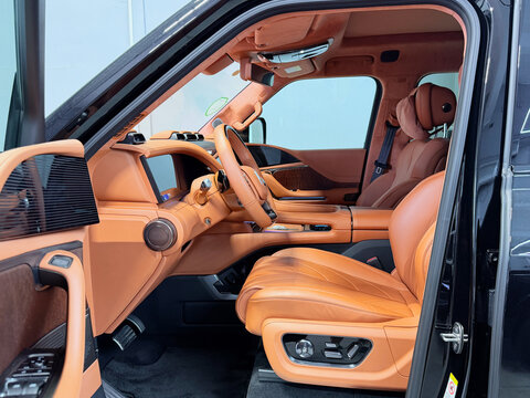 Modern luxurious brown leather interior of BYD Yangwang U8 premium electric SUV car with large dashboard digital display screen and high tech steering wheel. BYD Yangwang U8, a high-performance car. 